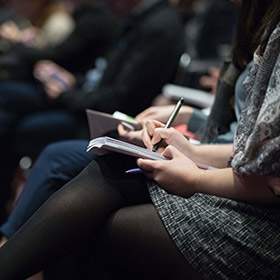 Woman sitting down and writing in notebook