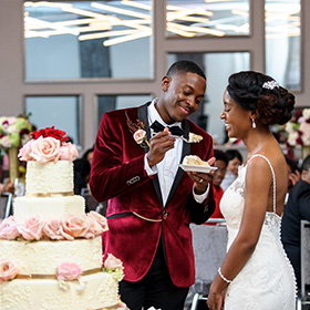 couple on wedding day eating wedding cake