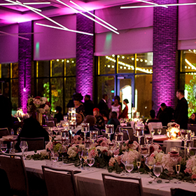 wedding reception tables with purple uplighting